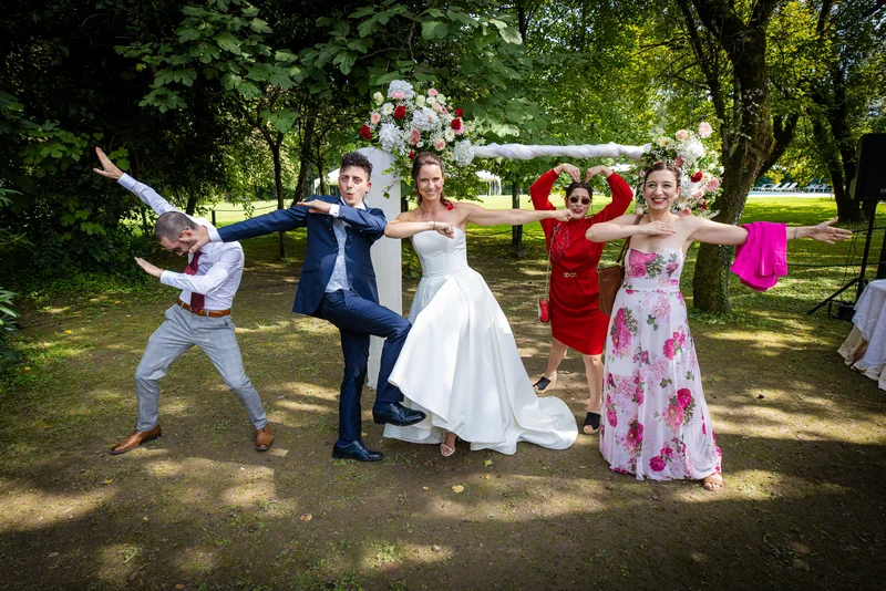 Gruppo di invitati in pose divertenti nel parco di Villa Luppis, circondati da alberi e decorazioni floreali.
