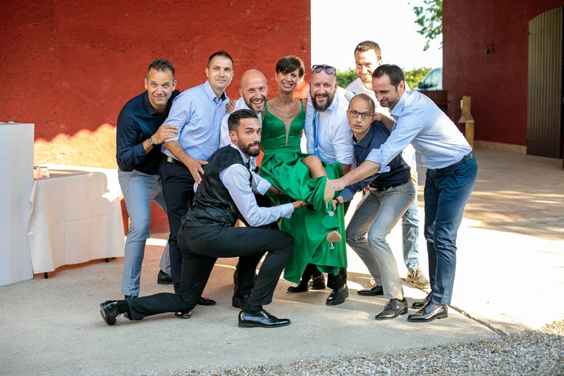 Gruppo di amici in abiti eleganti si divertono insieme all'aperto durante un evento di matrimonio.